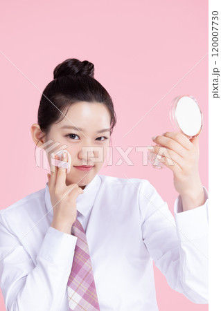 A teenage woman wearing a school uniform and holding cosmetics in a cute pose 120007730