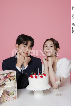 Newlywed couple smiling happily holding wedding cake 120007958