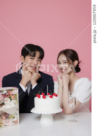 Newlywed couple smiling happily holding wedding cake 120007959