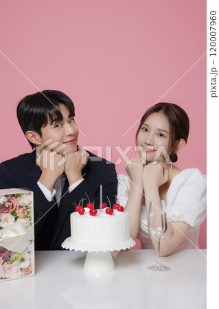 Newlywed couple smiling happily holding wedding cake 120007960