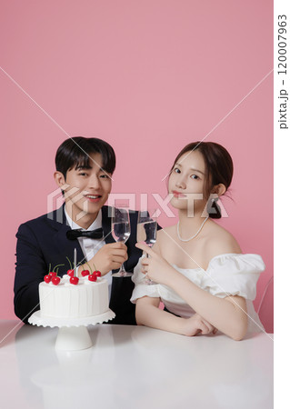 Newlywed couple smiling happily holding wedding cake Newlywed couple smiling happily holding wedding cake 120007963