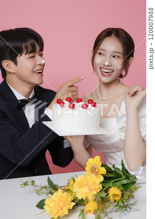 Newlywed couple smiling happily holding wedding cake 120007988