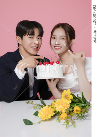 Newlywed couple smiling happily holding wedding cake 120007992