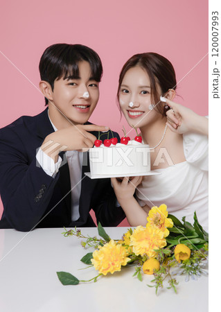 Newlywed couple smiling happily holding wedding cake Newlywed couple smiling happily holding wedding cake 120007993