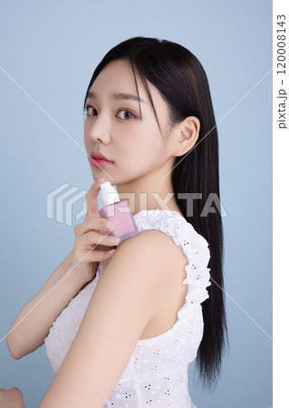 A woman in her 20s posing with a cool-toned lip product 120008143