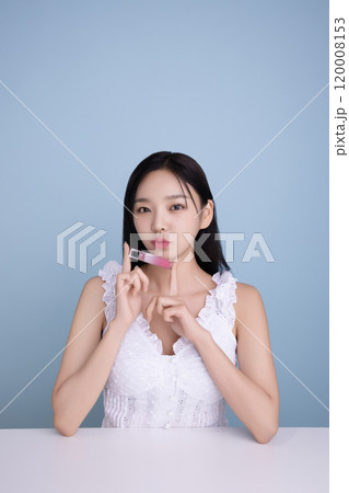 A woman in her 20s posing with a cool-toned lip product A woman in her 20s posing with a cool-toned lip product 120008153