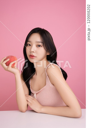 A woman in her 20s holding a peach and holding various poses A woman in her 20s holding a peach and holding various poses 120008202