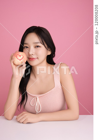 A woman in her 20s holding a peach and holding various poses A woman in her 20s holding a peach and holding various poses 120008208