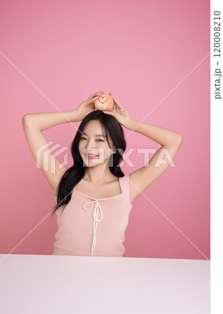A woman in her 20s holding a peach and holding various poses A woman in her 20s holding a peach and holding various poses 120008210