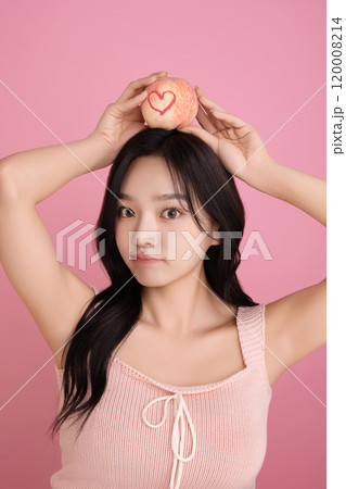 A woman in her 20s holding a peach and holding various poses A woman in her 20s holding a peach and holding various poses 120008214