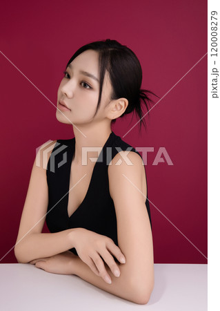A woman in her 20s posing in front of black poppy flowers 120008279