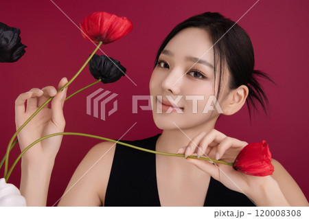 A woman in her 20s showing an elegant pose using poppy flowers 120008308