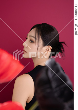 A woman in her 20s showing an elegant pose using poppy flowers 120008315