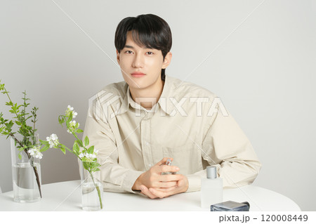 A man in his 20s posing with a perfume bottle A man in his 20s posing with a perfume bottle 120008449