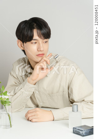 A man in his 20s posing with a perfume bottle 120008451