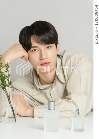 A man in his 20s posing with a perfume bottle A man in his 20s posing with a perfume bottle 120008454