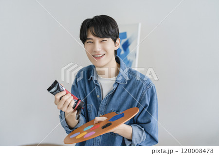 A man in his 20s holding art supplies A man in his 20s holding art supplies 120008478