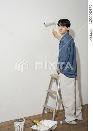 A man in his 20s painting a wall A man in his 20s painting a wall 120008479