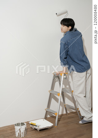 A man in his 20s painting a wall A man in his 20s painting a wall 120008480