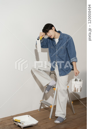 A man in his 20s painting a wall A man in his 20s painting a wall 120008494
