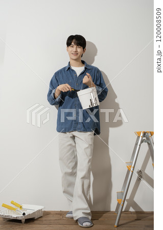 A man in his 20s painting a wall A man in his 20s painting a wall 120008509
