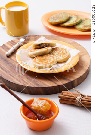 Hotteok, milk and honey plated on a wooden tray Hotteok, milk and honey plated on a wooden tray 120009528