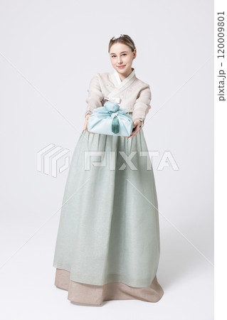 Western woman wearing Hanbok and holding a gift wrapped in Korean style 120009801