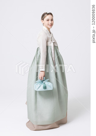 Western woman wearing Hanbok and holding a gift wrapped in Korean style Western woman wearing Hanbok and holding a gift wrapped in Korean style 120009836