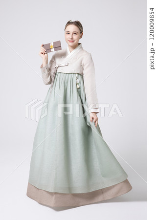 A foreign woman wearing traditional Korean hanbok holding a holiday gift 120009854