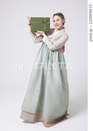 A foreign woman wearing traditional Korean hanbok holding a holiday gift 120009915
