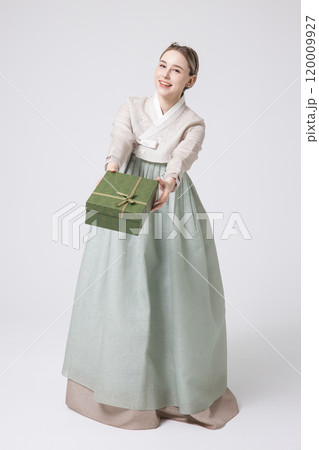 A foreign woman wearing traditional Korean hanbok holding a holiday gift 120009927