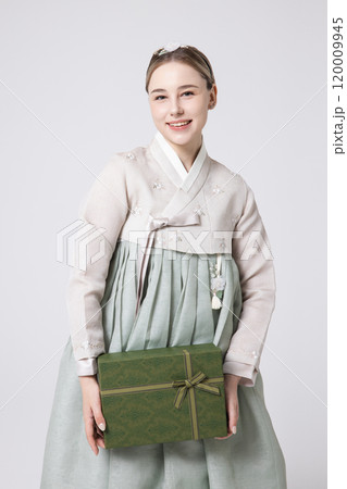 A foreign woman wearing traditional Korean hanbok holding a holiday gift 120009945