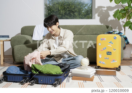 A man in his 20s preparing for a trip A man in his 20s preparing for a trip 120010009