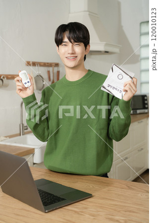 A man in his 20s uses a laptop to look up information to manage blood sugar levels 120010123