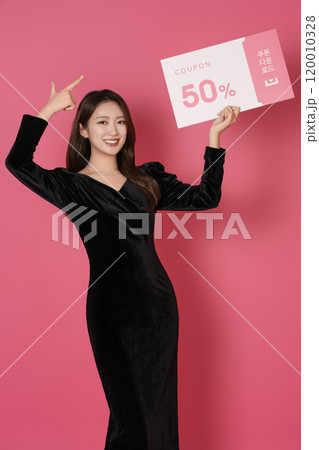 A woman in her 20s posing with a 50 percent discount coupon A woman in her 20s posing with a 50 percent discount coupon 120010328