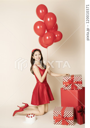 A woman in her 20s posing with a balloon A woman in her 20s posing with a balloon 120010371