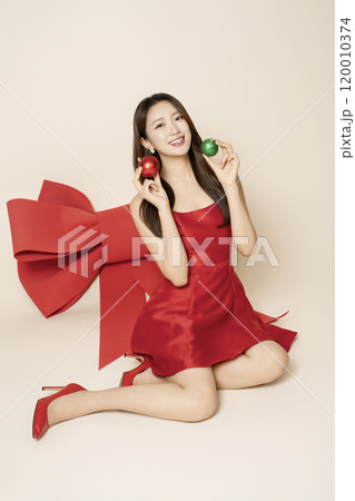 A woman in her 20s posing around a large ribbon A woman in her 20s posing around a large ribbon 120010374