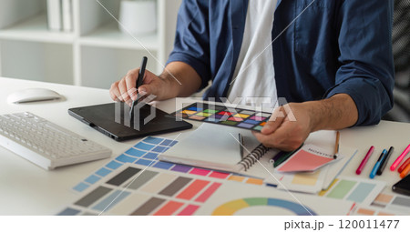 Graphic Designer Selecting Color Pairs on Computer for Creative Projects in Modern Workspace with Digital Tools and Color Swatches Graphic Designer Selecting Color Pairs on Computer for Creative Projects in Modern Workspace with Digital Tools and Color Swatches 120011477