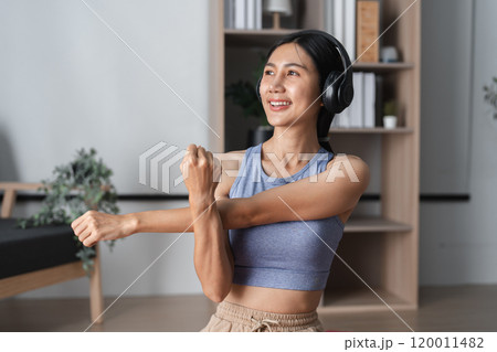 Young Woman Practicing Yoga Indoors, Stretching Muscles for Relaxation and Flexibility in a Modern Home Setting Young Woman Practicing Yoga Indoors, Stretching Muscles for Relaxation and Flexibility in a Modern Home Setting 120011482