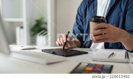 Graphic Designer Selecting Color Pairs on Computer for Creative Design Projects in Modern Workspace with Digital Tools and Coffee 120011492