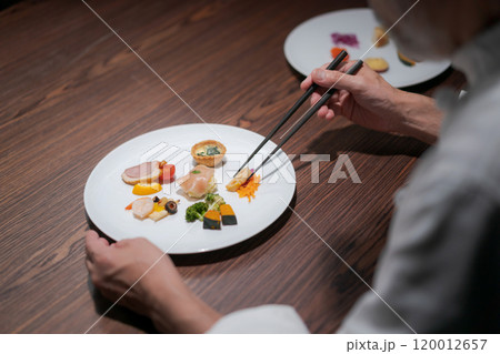 料理の味見をする男性シェフ 料理の味見をする男性シェフ 120012657