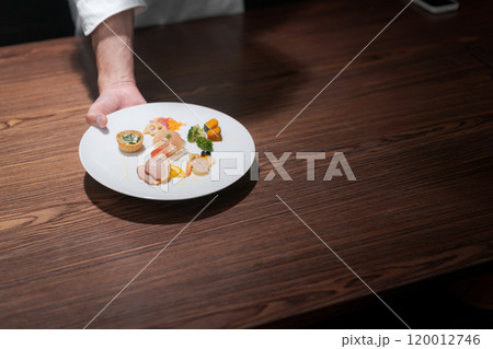 料理を出す男性シェフの手 120012746