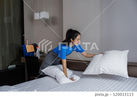 cleaning service woman worker clean bedroom at hotel. housekeeper cleaner feel happy and make bed look neat. housework and housekeeping cleaning service 120013115