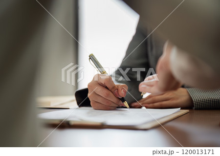 Hands of lawyer pointing at paper for businessman signing contract. legal advisor helping mature client to fill up document 120013171