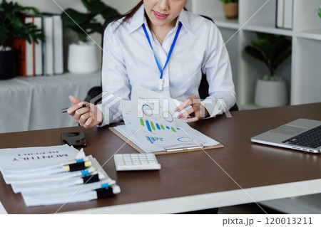 Businesswoman analyzing marketing strategy with document about company profit Businesswoman analyzing marketing strategy with document about company profit 120013211