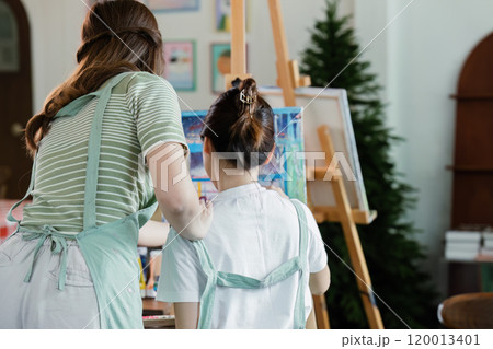 beautiful young woman artist working on painting something on a large canvas beautiful young woman artist working on painting something on a large canvas 120013401