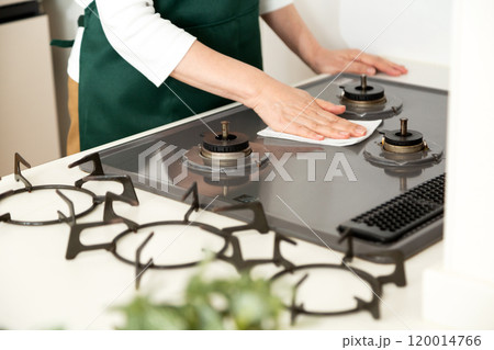 ガスコンロを拭き掃除するミドル〜シニア女性の手元 ガスコンロを拭き掃除するミドル〜シニア女性の手元 120014766