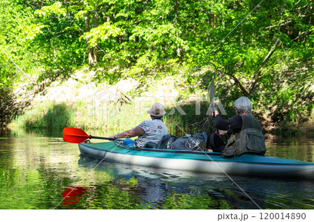 Family kayak trip for seigneur and senora. An elderly married couple rowing a boat on the river, a water hike, a summer adventure. Age-related sports, mental youth and health, tourism, active old age Family kayak trip for seigneur and senora. An elderly married couple rowing a boat on the river, a water hike, a summer adventure. Age-related sports, mental youth and health, tourism, active old age 120014890