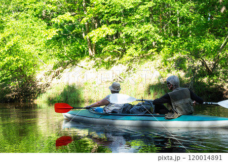 Family kayak trip for seigneur and senora. An elderly married couple rowing a boat on the river, a water hike, a summer adventure. Age-related sports, mental youth and health, tourism, active old age Family kayak trip for seigneur and senora. An elderly married couple rowing a boat on the river, a water hike, a summer adventure. Age-related sports, mental youth and health, tourism, active old age 120014891
