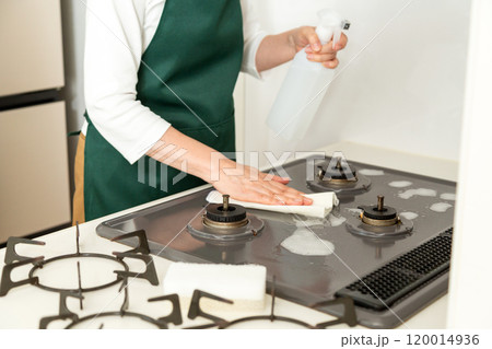 ガスコンロを拭き掃除するミドル〜シニア女性の手元 ガスコンロを拭き掃除するミドル〜シニア女性の手元 120014936
